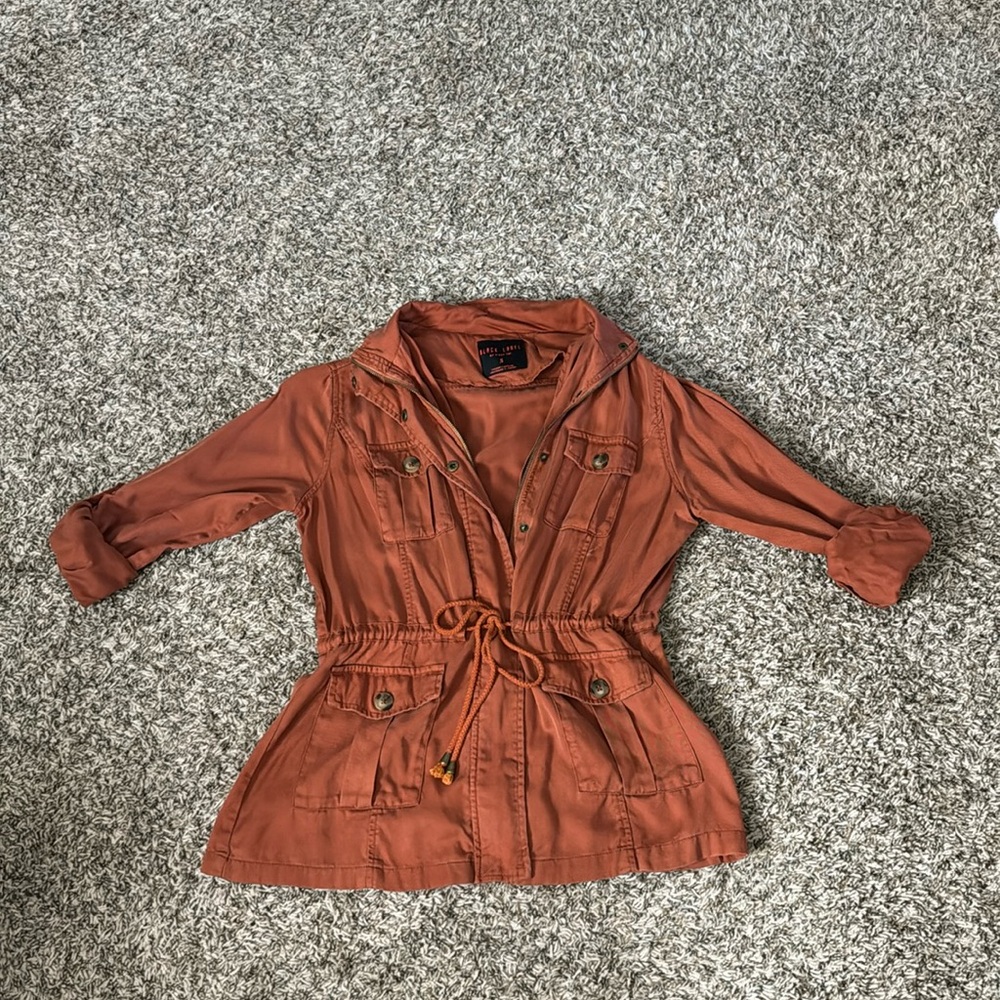 Orangish red tone. Great fall color. It’s a light jacket really just for style